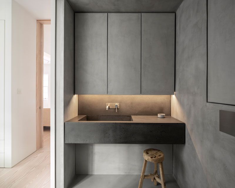Sleek microcement bahtroom cupboards and concrete sink.
